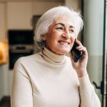 Elderly woman speaking on a phone call at home