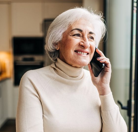 Elderly woman speaking on a phone call at home
