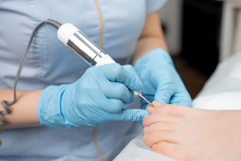 Femme offrant des soins de pieds à une personne atteinte d'un cancer